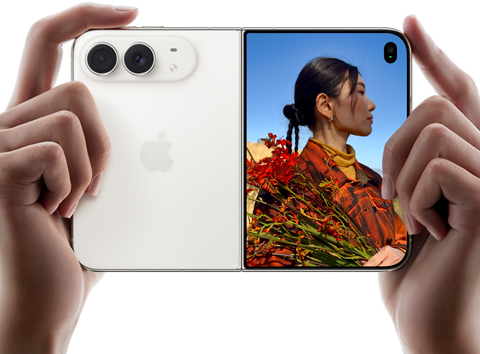 iPhone Duo, звездно бяло, държан в две ръце в хоризонтална ориентация, разгънат, левият панел показва 48MP Dual Fusion задни камери, а десният панел показва човек, когото снимат на външния дисплей, обектът на снимката вижда лицето си, докато го снимат с Duo Preview