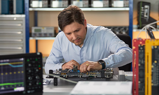 Greg arbeitet in einem Hardware Engineering Lab inmitten von Testinstrumenten für Chips.