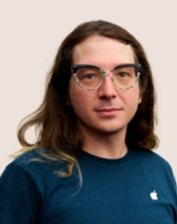 안경을 쓰고 있는 Apple Retail 팀원의 인물 사진.