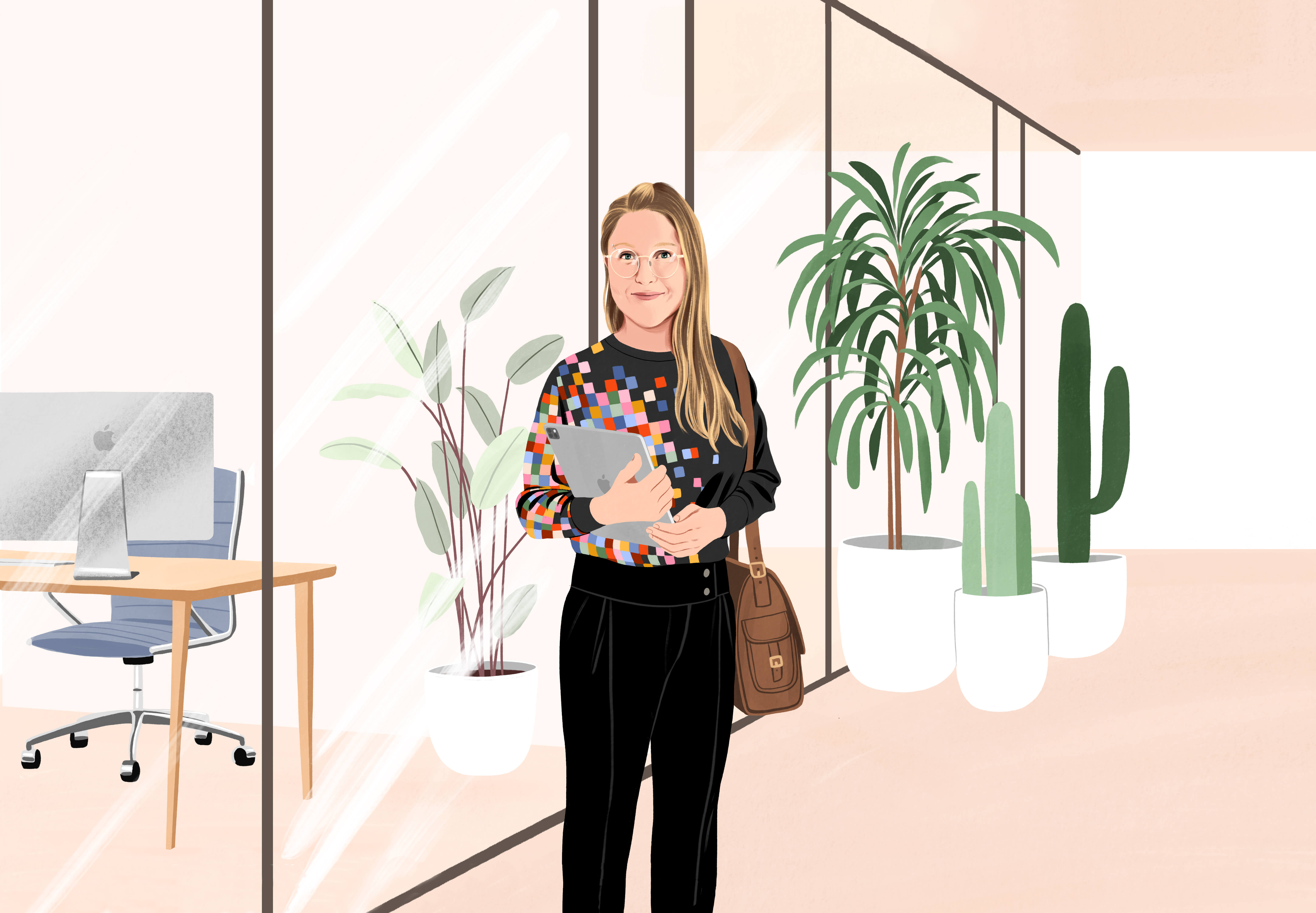 Manuela står på en kontorgang og smiler med en iPad i hånden og en taske over skulderen. Hun har sorte bukser på og en sort bluse med et farverigt pixelmønster ned over den ene side.