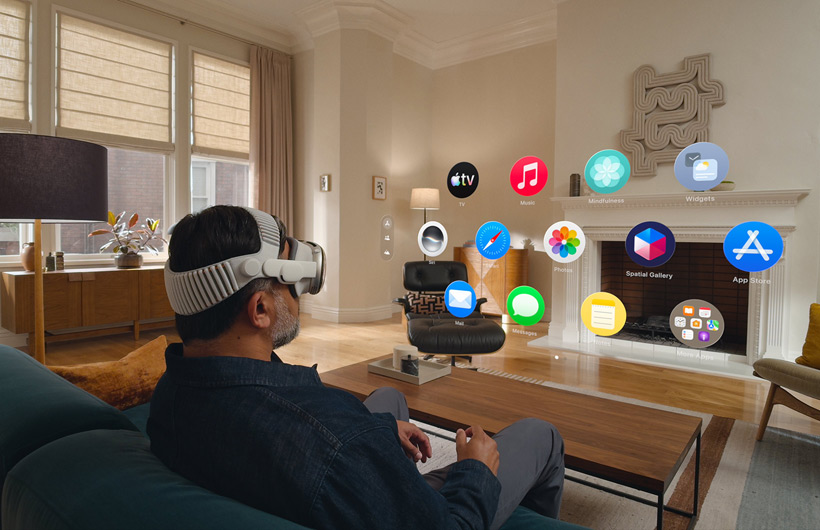 Une personne assise sur un canapé avec l’Apple Vision Pro lance la Vue d’accueil