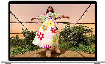 Layar MacBook Air menampilkan foto seseorang mengenakan pakaian berwarna-warni, yang memperlihatkan color range dan resolusi layar Liquid Retina