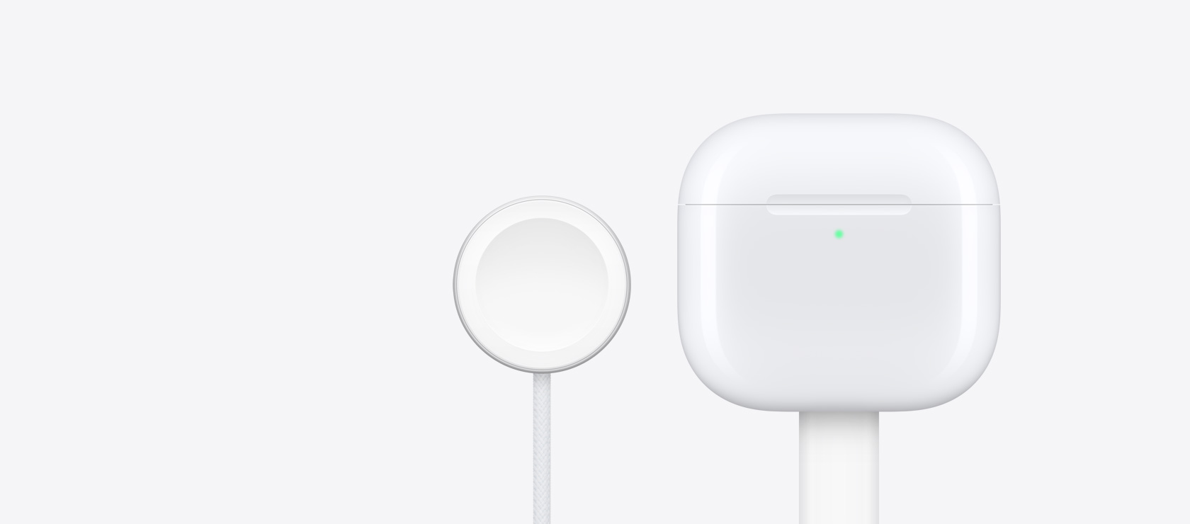 Airpods 4 uzlādes kārbiņa līdzās Apple Watch lādētājam.