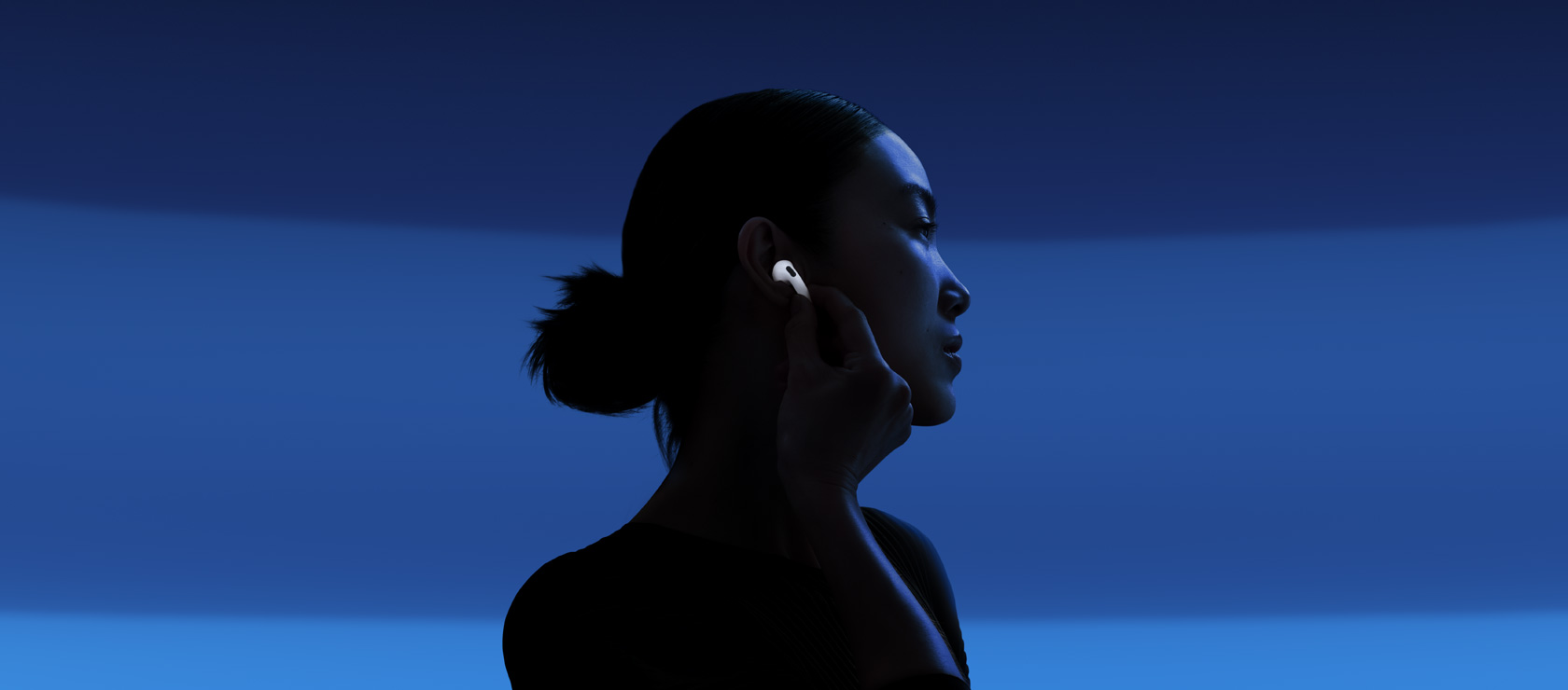 سيدة تشغِّل ميزة إلغاء الضجيج النشط عن طريق لمس جذع سماعة AirPods 5