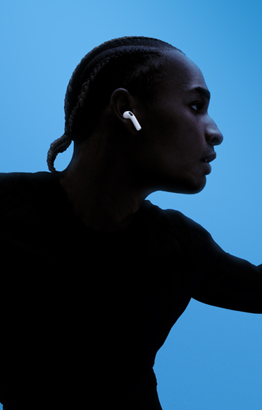 شخص يضع سماعات AirPods 5، ذراعان مفتوحتان، خلفية ملونة