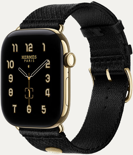 Apple Watch Hermès Series 12, carátula Clou de Selle analógica (agujas de hora, minuto y segundo, complicaciones: fase lunar, fecha), caja de titanio, color oro radiante, parte lateral derecha, Digital Crown, botón lateral, con la correa Noir Satin Clou de Selle, suave tejido satinado negro con componentes en color oro radiante que hacen juego con la caja del reloj