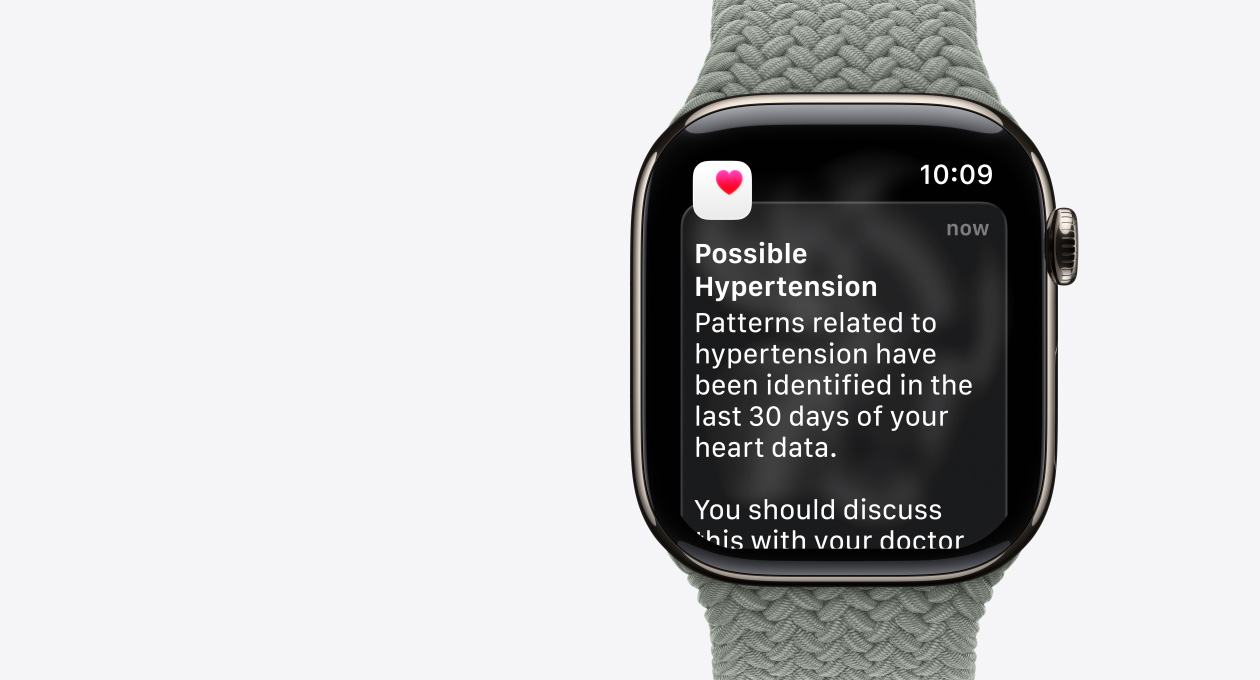 Apple Watch Series 11, naturaalne toon, titaanist korpus, võimaliku hüpertensiooni teavitus, roosa süda valges karbis, parema külje välisülg, Digital Crown, rihm, rohekashall punutud rihm Braided Solo Loop