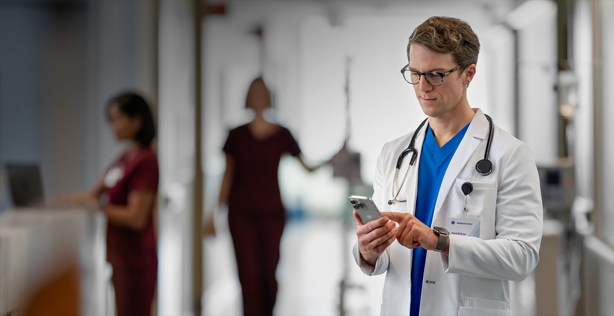 Un profesional sanitario mira su iPhone en un hospital.