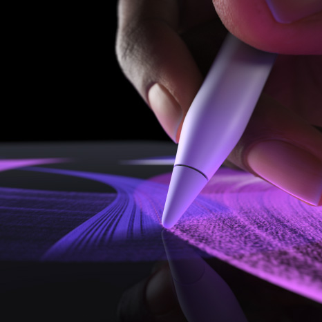 Apple Pencil Pro, vue latérale, blanc, main tenant un crayon et dessinant une ligne de pinceau d’un bleu éclatant