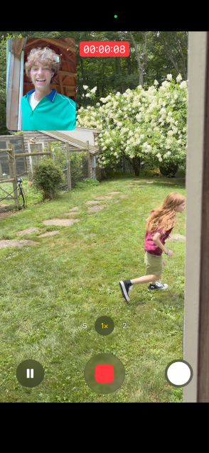 iPhone 17 screen using front and rear camera dual capture video of young girl running while man watches
