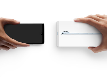 Hands exchanging phones, Android on the left without a box, on the right is a new iPhone Air in box