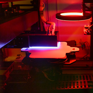 Manufacturing equipment illuminated by red and blue light in a factory