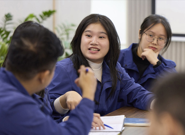 Employees in classroom setting collaborate or share learning